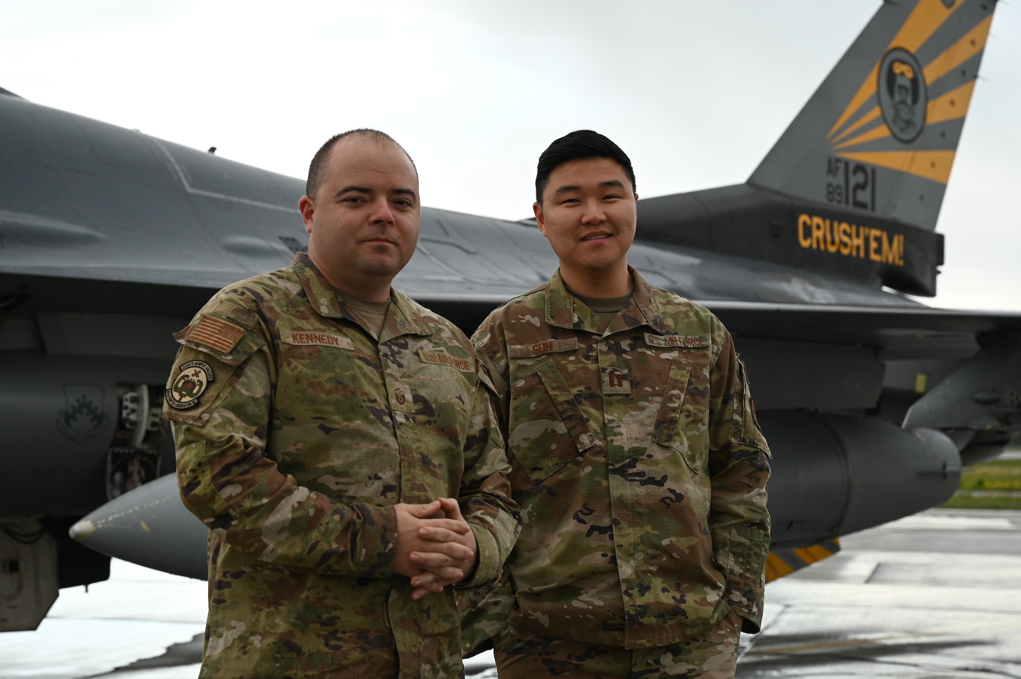 U.S. Air Force Master Sgt. Carleton Kennedy, left, 80th Fighter Generation Squadron production supervisor, and Capt. Sung Woo Suh, 80th FGS Director of Operations, pose for a photo in front of an F-16 Fighting Falcon assigned to the 80th Fighter Squadron at Eielson Air Force Base Alaska, June 13, 2023. While deployed to Eielson in support of RED FLAG-Alaska, Suh and Kennedy were recognized for saving an infant, father and dog from drowning and hypothermia when their kayak capsized in Chena Lake Recreation Area, Alaska on June 3, 2023.(U.S. Air Force photo by Airman Carson Jeney)