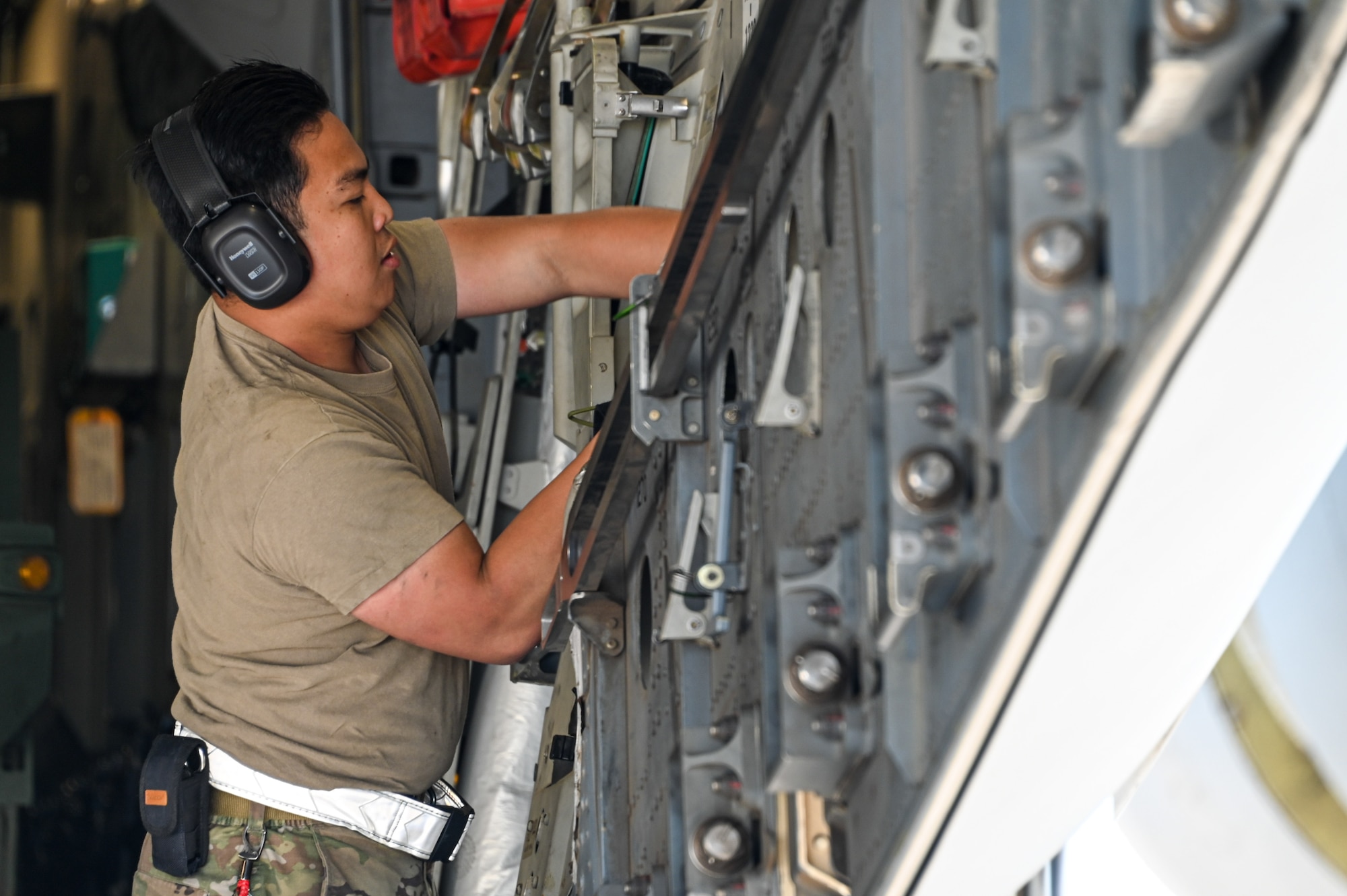 U.S. Air Force Senior Airman Kevin Lim, 97th Logistics Readiness Squadron (LRS) unilateral aircrew training element member, places equipment on the cargo loading wall of a C-17 Globemaster III at Fort Smith Arkansas, June 14, 2023. Two members from the 97th LRS completed training and real-world exercises during the joint-operation. (U.S. Air Force photo by Senior Airman Kayla Christenson)