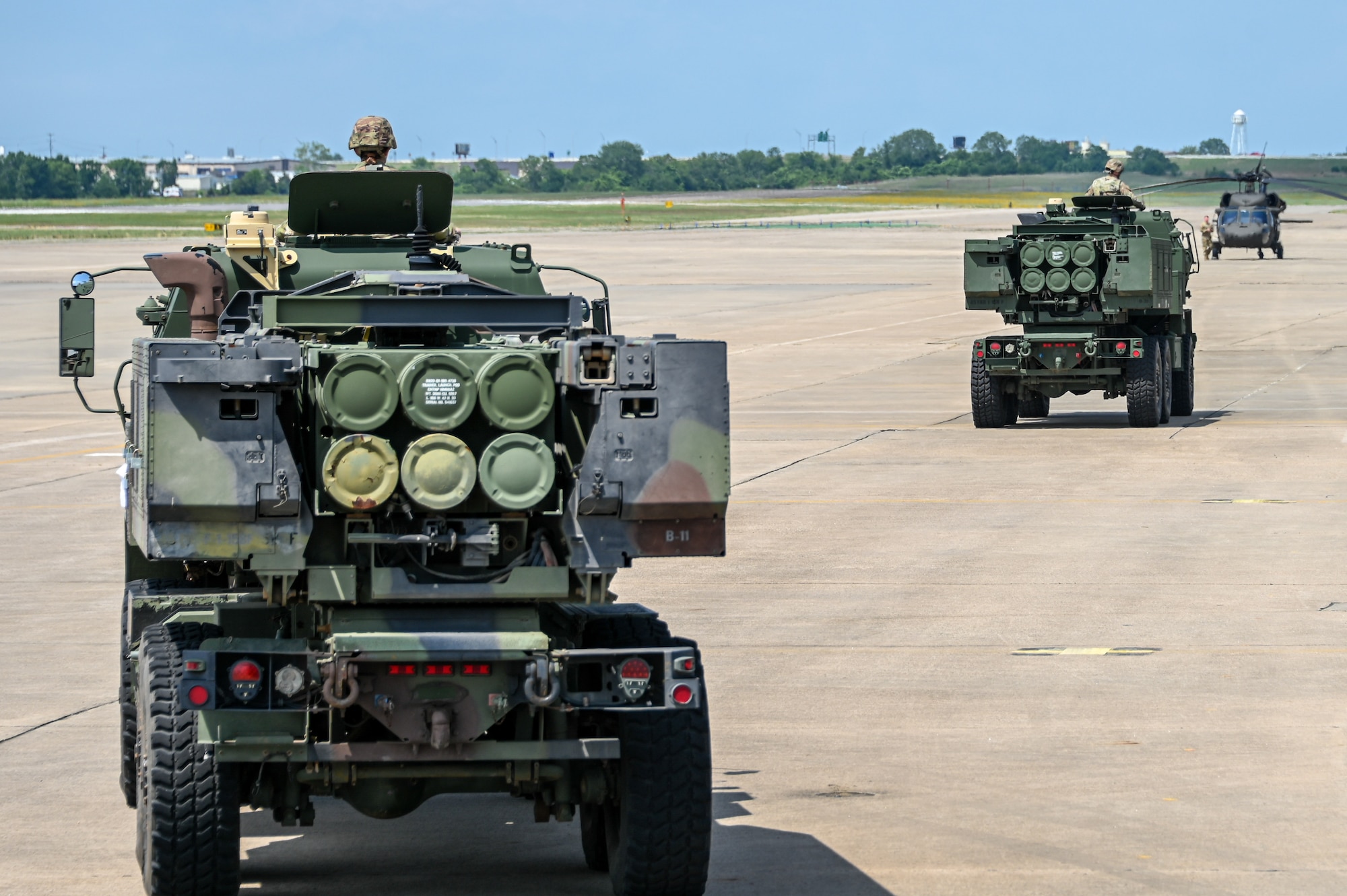 M142 High Mobility Artillery Rocket Systems (HIMARS) drive away after simulating combat offloading from a C-17 Globemaster III at Fort Smith Arkansas, June 14, 2023. The HIMARS can launch six Multiple Launch Rocket System Family of Munitions rockets and missiles. (U.S. Air Force photo by Senior Airman Kayla Christenson)