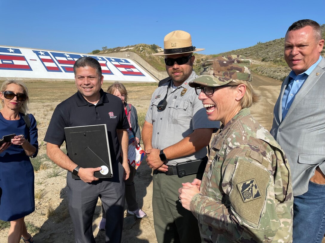 Col. Julie Balten, second from right, U.S. Army Corps of Engineers Los Angeles District commander, joins her LA District team in celebrating the unveiling of the newly restored bicentennial mural June 2 at Prado Dam in Corona, California.
