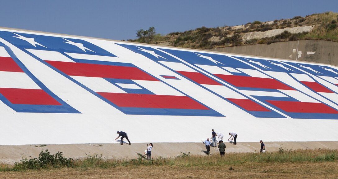 Members of One Way Painting and other guests of the June 2 bicentennial mural unveiling add some finishing touches before the ceremony at Prado Dam in Corona, California.