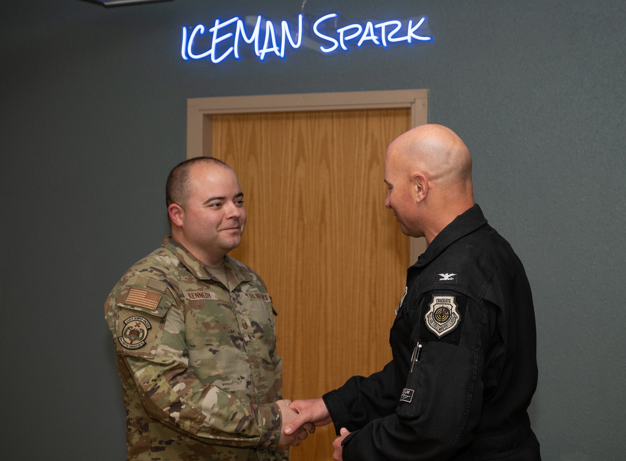 U.S. Air Force Col. David Berkland, 354th Fighter Wing commander, right, coins Master Sgt. Carleton Kennedy, 80th Fighter Generation Squadron production supervisor, at Eielson Air Force Base Alaska, June 9, 2023. While deployed to Eielson in support of RED FLAG-Alaska, Kennedy, along with the 80th FGS Director of Operation Capt. Sung Woo Suh, were recognized for saving an infant, father and dog from drowning and hypothermia when their kayak capsized in Chena Lake Recreation Area, Alaska on June 3, 2023. (U.S. Air Force photo by Staff Sgt. Danielle Sukhlall)