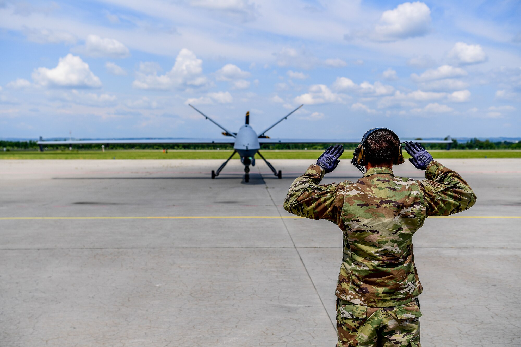 A 147th Attack Wing member marshals an MQ-9 Reaper June 13, 2023, at Ostrava Airport, Czech Republic. Exercise Air Defender 2023 integrates U.S. and allied air power to defend shared values, while leveraging and strengthening vital partnerships to deter aggression around the world.