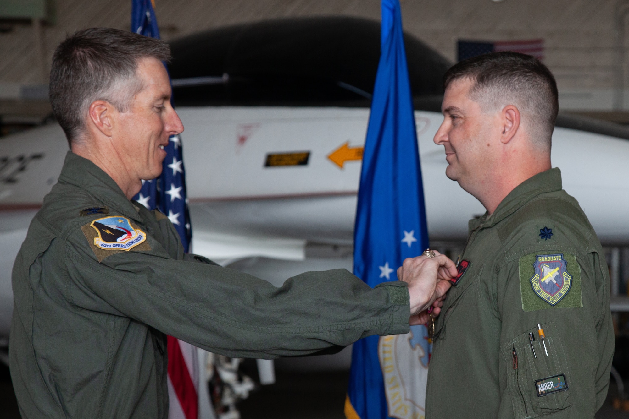 Col. Grant Mizell, 412th Operations Group Commander, pins on the Meritorious Service Medal to Lt. Col. Adam Brooks, the outgoing Emerging Technologies Combined Test Force Director, during a ET-CTF’s change of command ceremony on Edwards Air Force Base, California, June 7. (Air Force photo by Carla Escamilla)