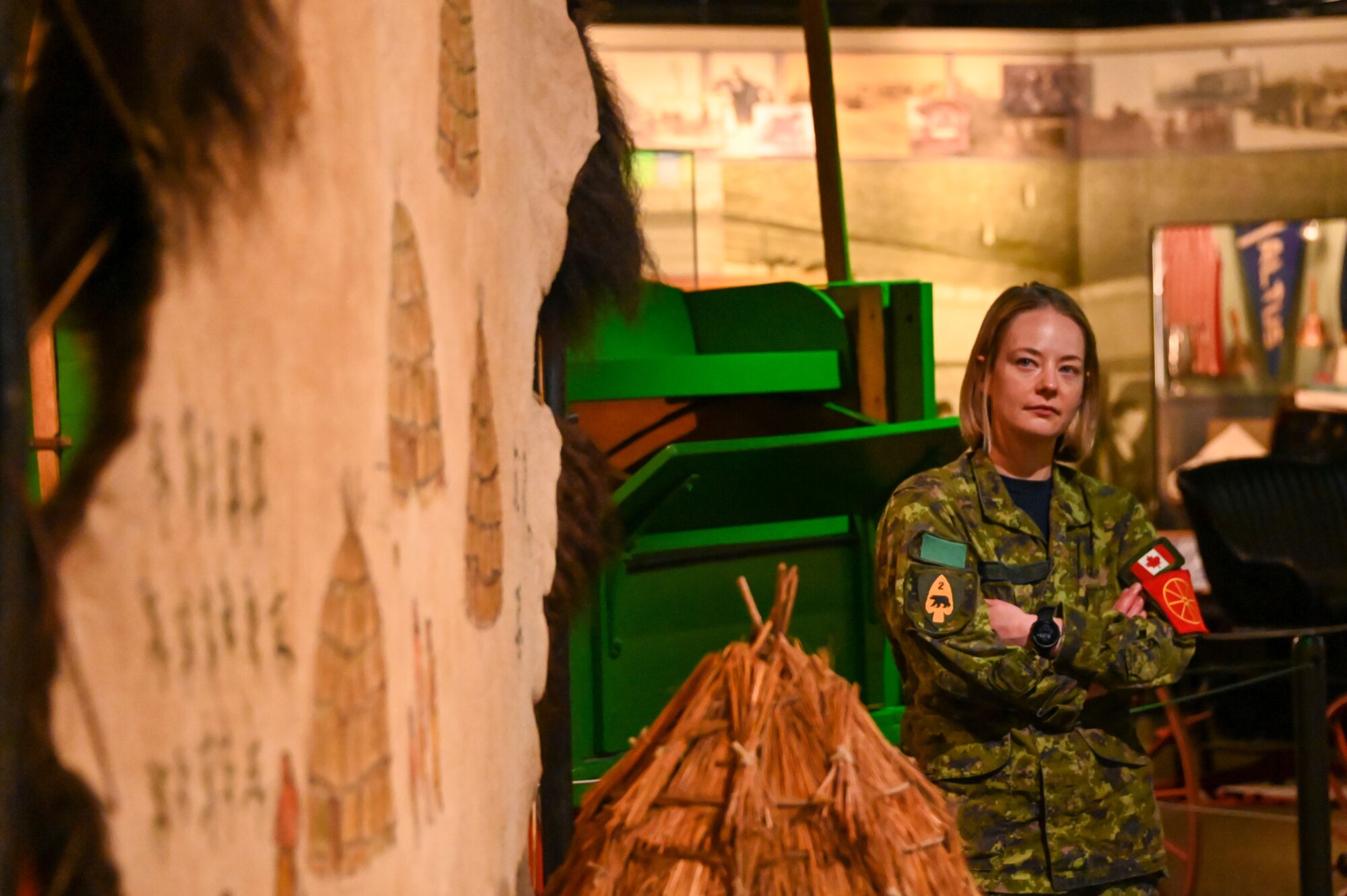 Royal Canadian air force Cpl. Emily Mountney-Lessard, 2nd Service Battalion traffic technician, poses near a buffalo hide painting in the Museum of the Western Prairie during a tour of Altus, Oklahoma, May 19, 2023. International students visited several places in Southwestern Oklahoma during their time at Altus Air Force Base, Oklahoma, learning more about American culture. (U.S. Air Force photo by Senior Airman Kayla Christenson)