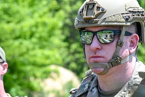 Senior Master Sgt. Daniel Chase, the Integrated Defense Leadership Course chief assigned to the 310th Security Forces Squadron, Schriever Space Force Base, Colorado, observes a safety briefing prior to using a live grenade on May 31, 2023, at Camp James A. Garfield Joint Military Training Center, Ohio.