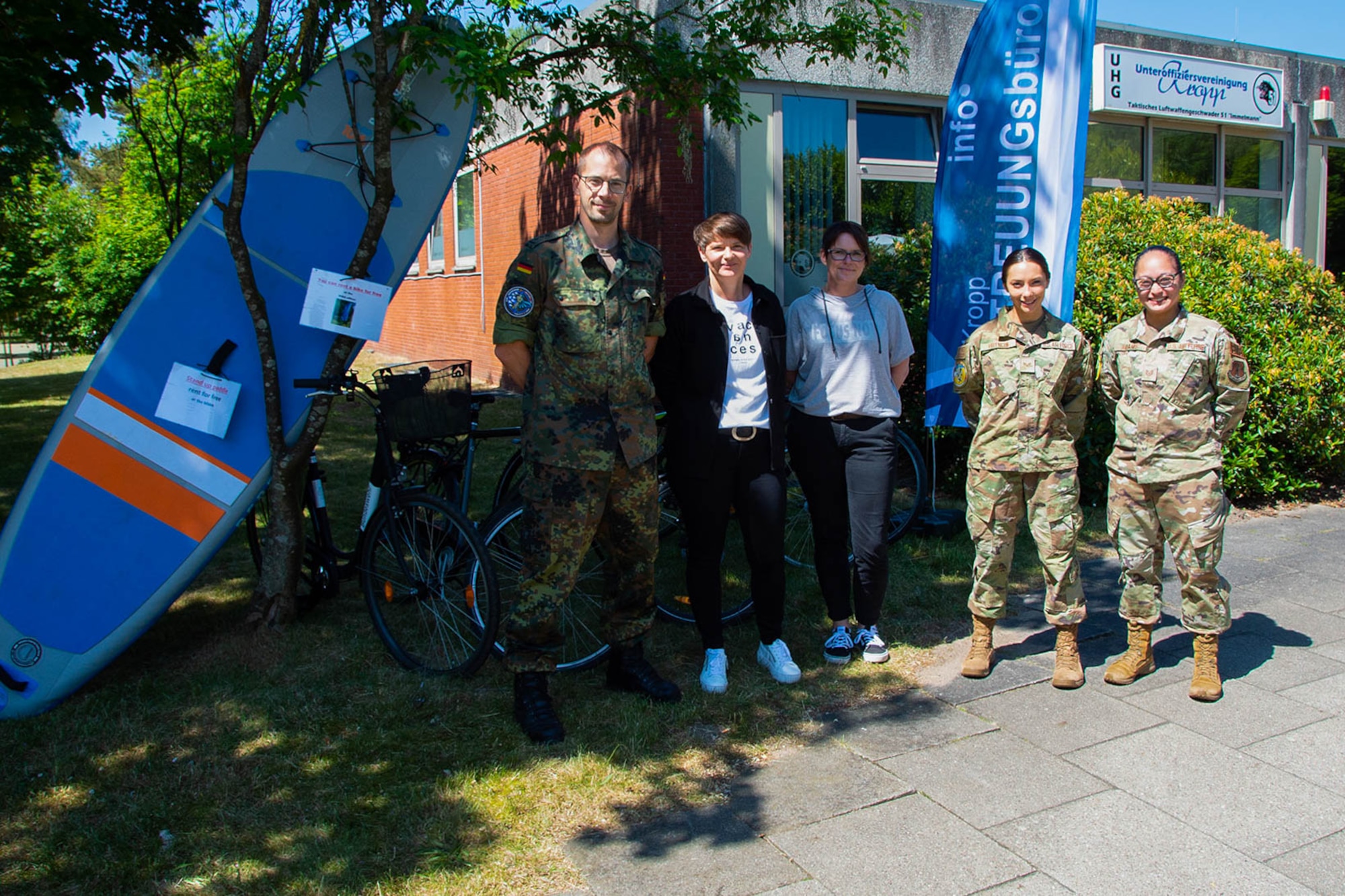 People in a line, some German some American, some civilian military.