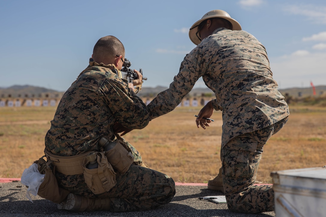 A U.S. Marine Corps marksmanship instructor, with Weapons Field Training Battalion, instructs a recruit with Hotel Company, 2nd Recruit Training Battalion, during the table one course of fire at Marine Corps Base Camp Pendleton, Calif., June 20, 2023. Table one covered the basic fundamentals of marksmanship and rifle safety in all shooting positions sitting, kneeling, and prone. (U.S. Marine Corps photo by Lance Cpl. Alvarez)