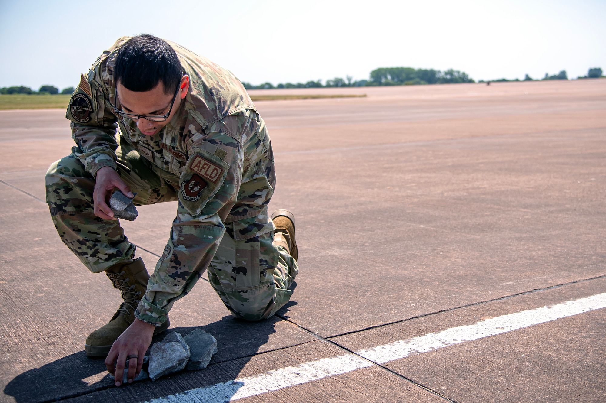 U.S. Air Force Senior Airman Daniel Ybarra, 420th Operations Squadron airfield management shift lead, conducts a foreign  object debris check on the flight line at RAF Fairford, England, June 14, 2023. Ybarra along with multiple Airmen deployed to Fairford to support Bomber Task Force 23-3. Support operations executed by units like Ybarra’s are key in ensuring the U.S. Air Force is postured and ready with a credible force to assure, deter, and defend in an increasingly complex security environment. (U.S. Air Force photo by Staff Sgt. Eugene Oliver)