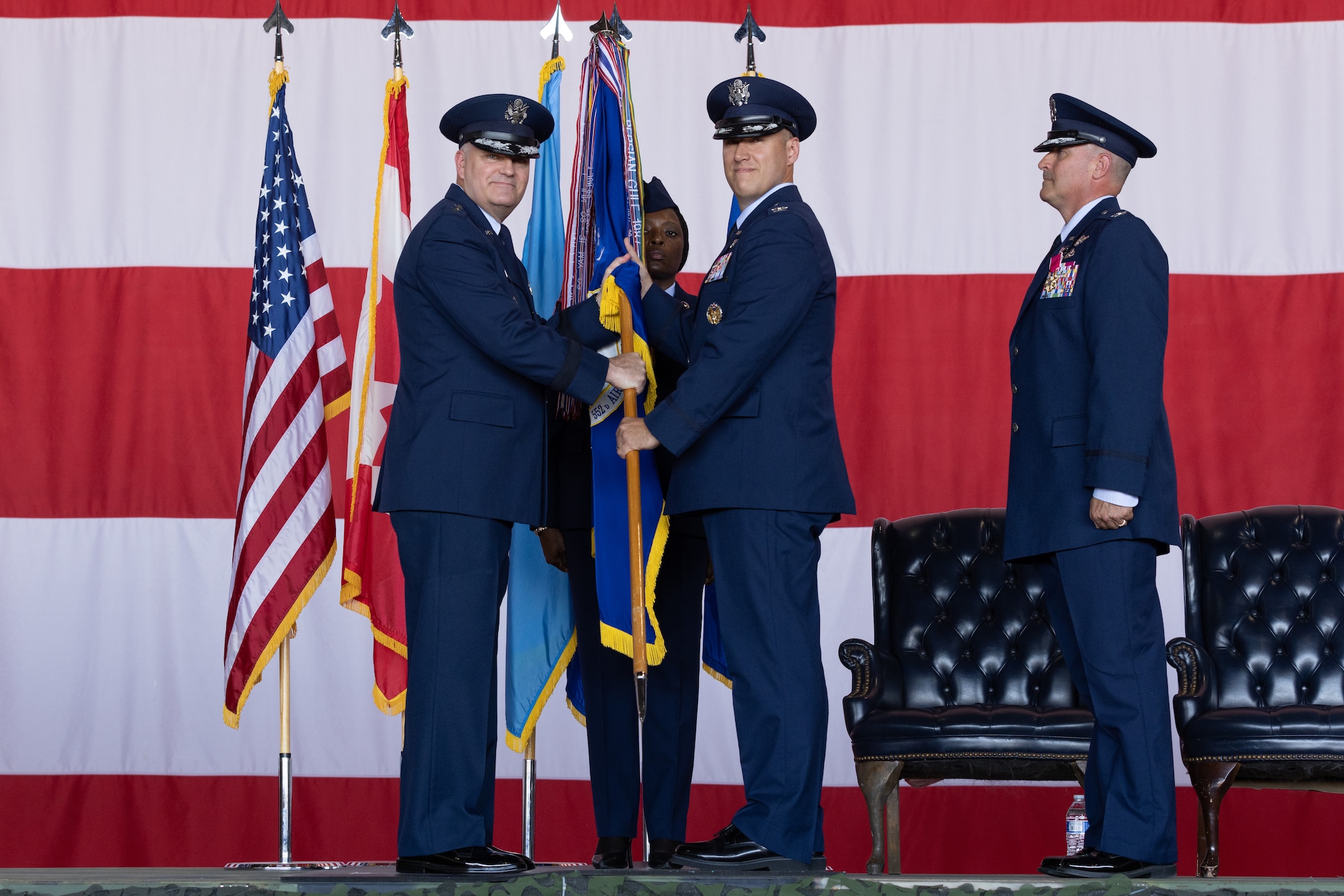 Two men holding guidon on stage