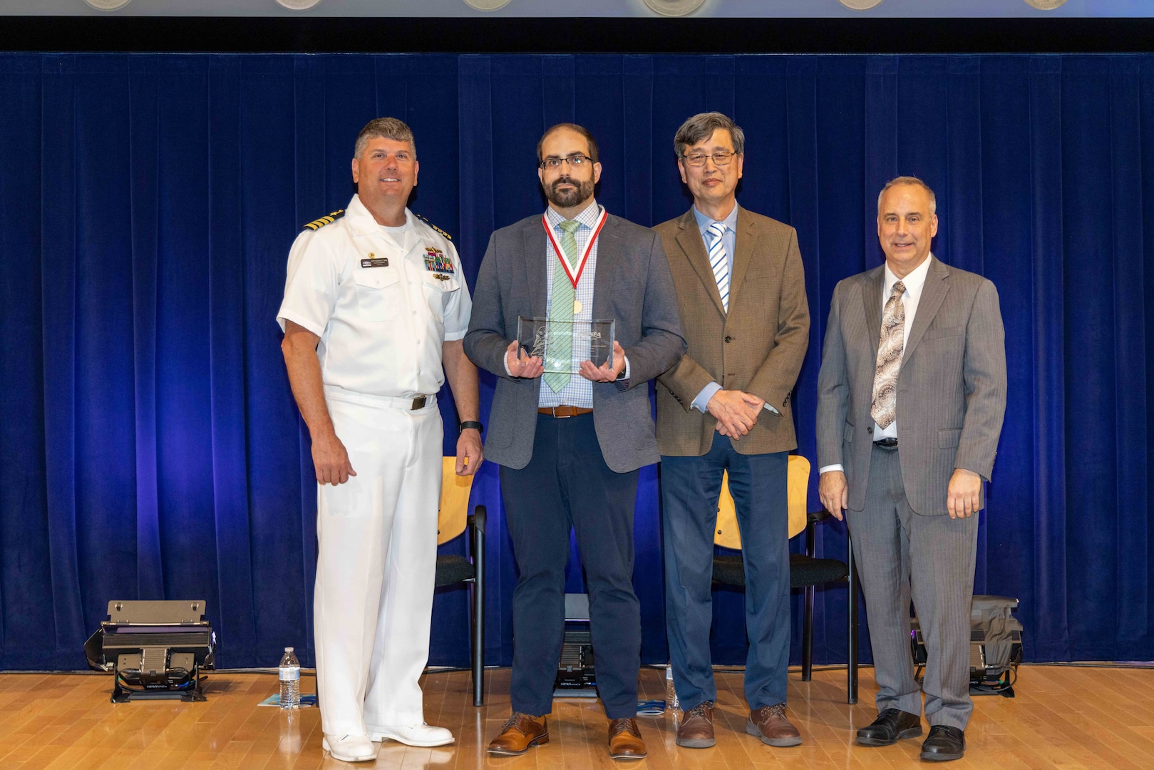 Naval Surface Warfare Center, Carderock Division's Commanding Officer Capt. Matthew Tardy (left), Technical Director Larry Tarasek (right) and Dr. Paul Shang (second to right), the Signatures Department Head, present the Rear Adm. George W. Melville Award for Engineering Excellence to James Sracic, a mechanical engineer in the Submarine Onboard Signatures Branch, during Carderock's Magnificent Eight Award ceremony in West Bethesda, Md., on June 13. (U.S. Navy photo by Aaron Thomas)