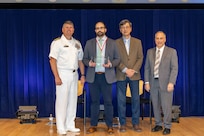Naval Surface Warfare Center, Carderock Division's Commanding Officer Capt. Matthew Tardy (left), Technical Director Larry Tarasek (right) and Dr. Paul Shang (second to right), the Signatures Department Head, present the Rear Adm. George W. Melville Award for Engineering Excellence to James Sracic, a mechanical engineer in the Submarine Onboard Signatures Branch, during Carderock's Magnificent Eight Award ceremony in West Bethesda, Md., on June 13. (U.S. Navy photo by Aaron Thomas)