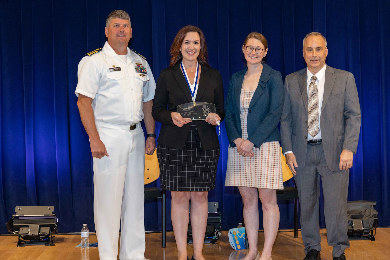 Naval Surface Warfare Center, Carderock Division's Commanding Officer Capt. Matthew Tardy (left), Technical Director Larry Tarasek (right) and Nancy Adler (second to right), the Platform Integrity Department's Deputy Department Head, present the Vice Adm. Samuel L. Gravely Jr. Award for Achievement in Diversity and Inclusion to Danielle Gerstner (second to left), Materials for Advanced Systems and Sensors Branch Head, during Carderock's Magnificent Eight Award ceremony in West Bethesda, Md., on June 13. (U.S. Navy photo by Aaron Thomas)
