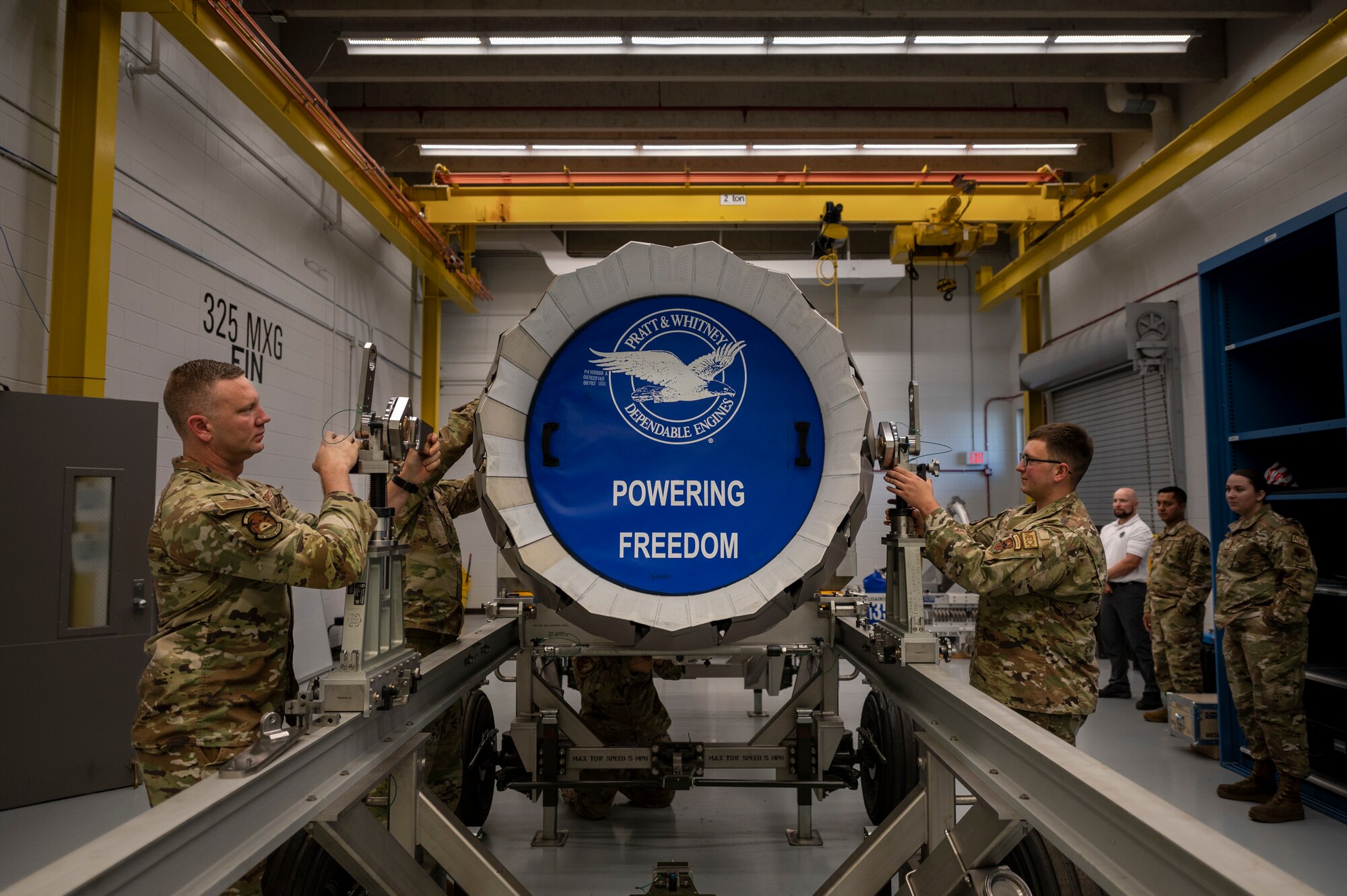 Airmen perform maintenance on an engine