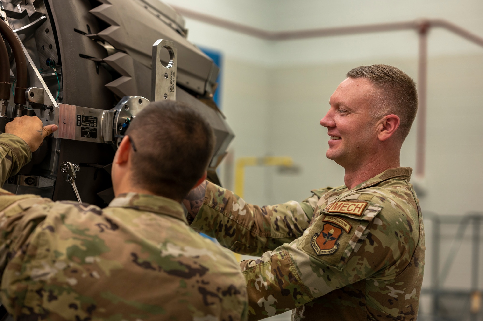 Airmen perform maintenance on an engine