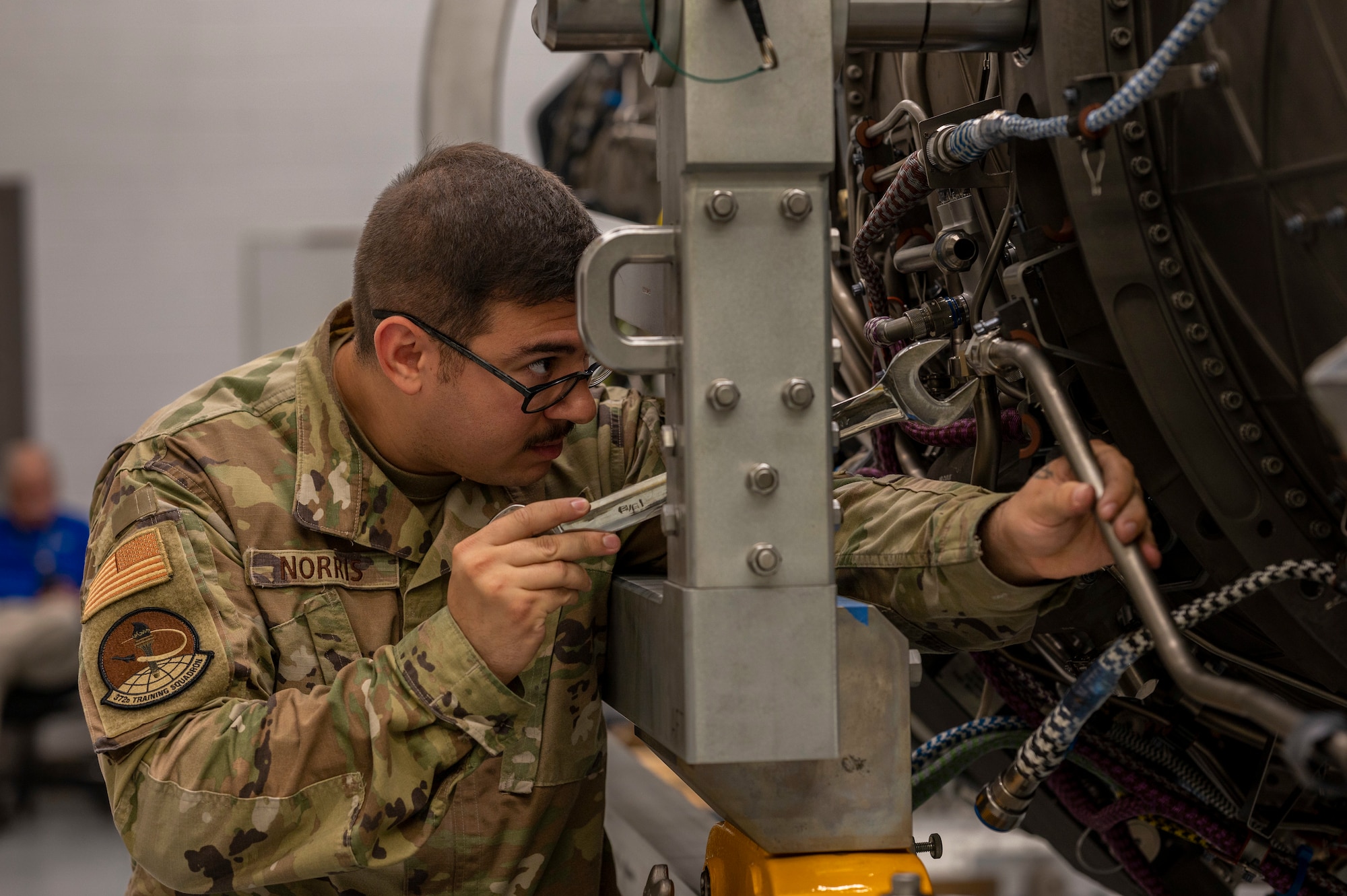 Airmen perform maintenance on an engine