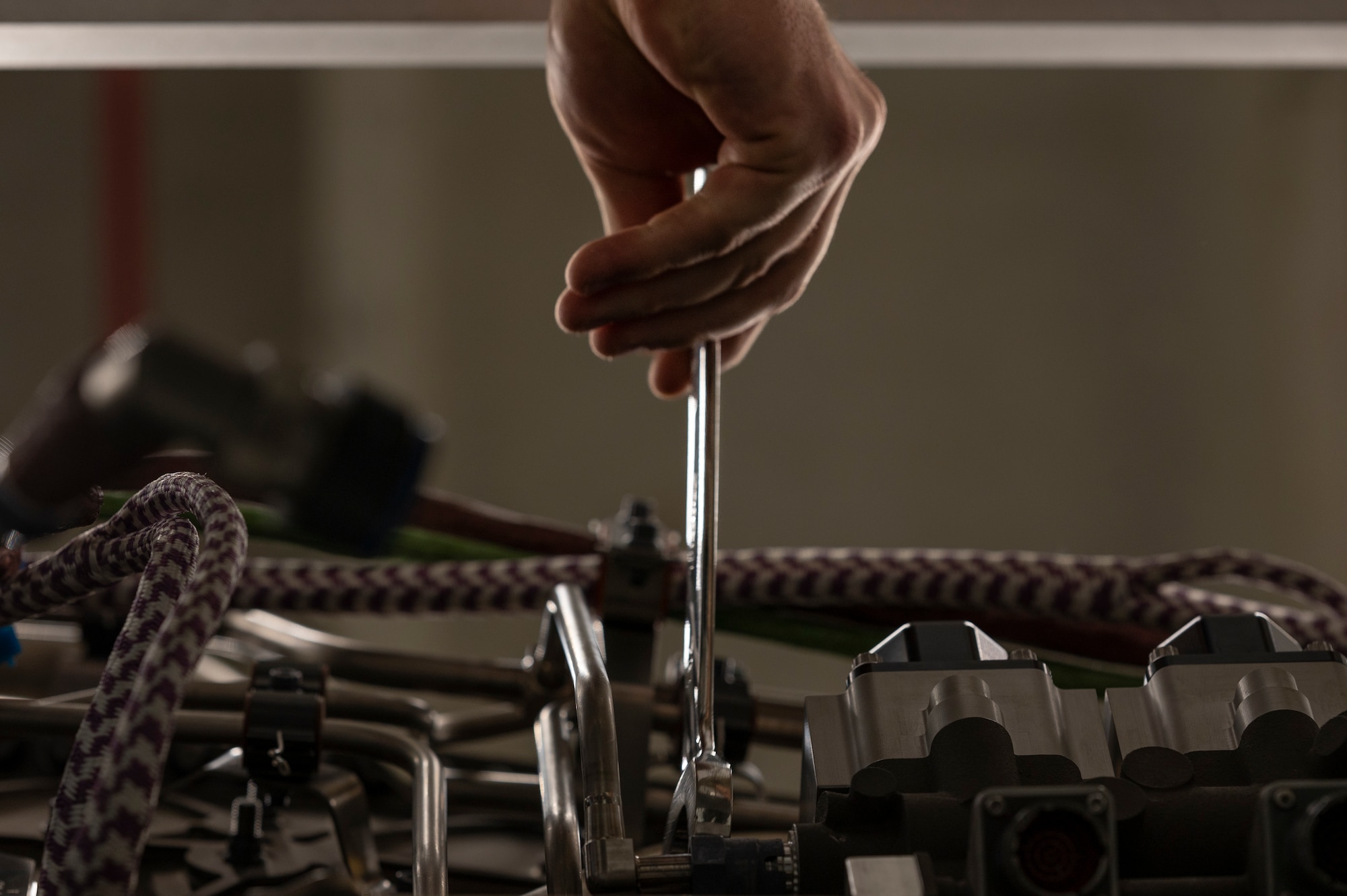 Airmen perform maintenance on an engine