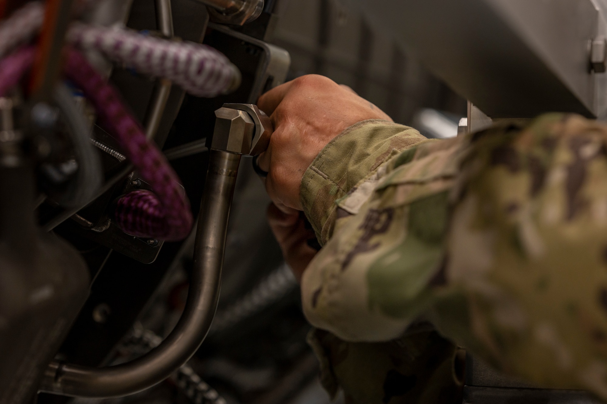 Airmen perform maintenance on an engine