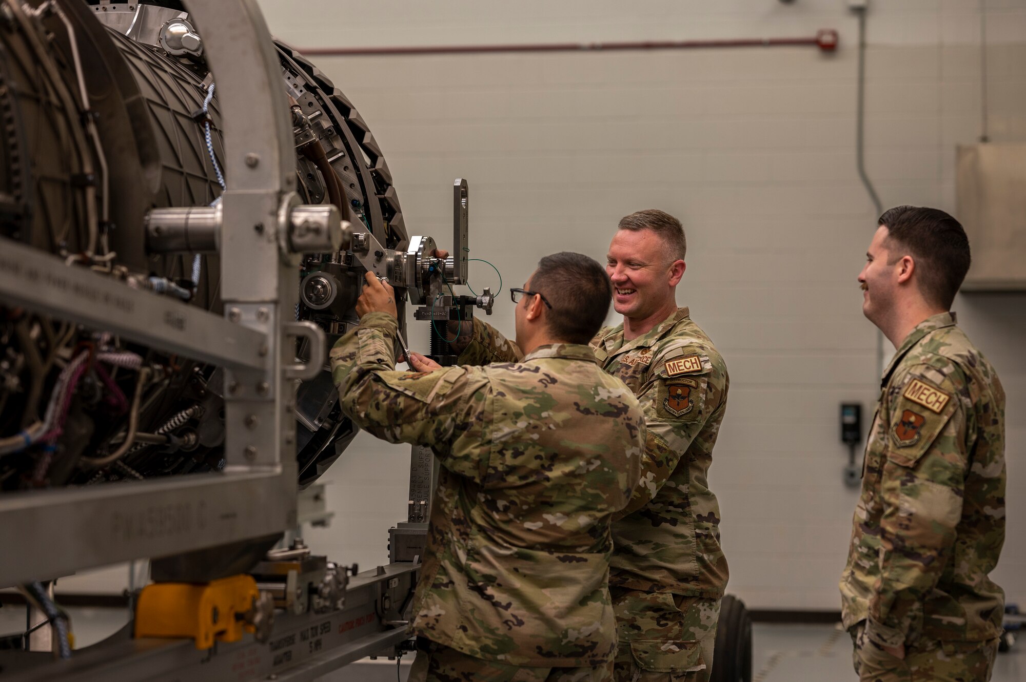 Airmen perform maintenance on an engine