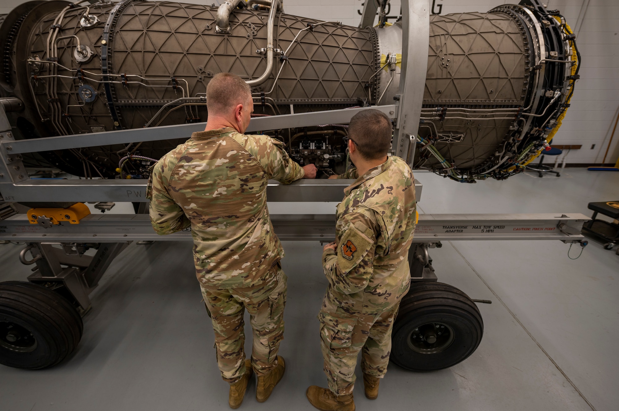 Airmen perform maintenance on an engine