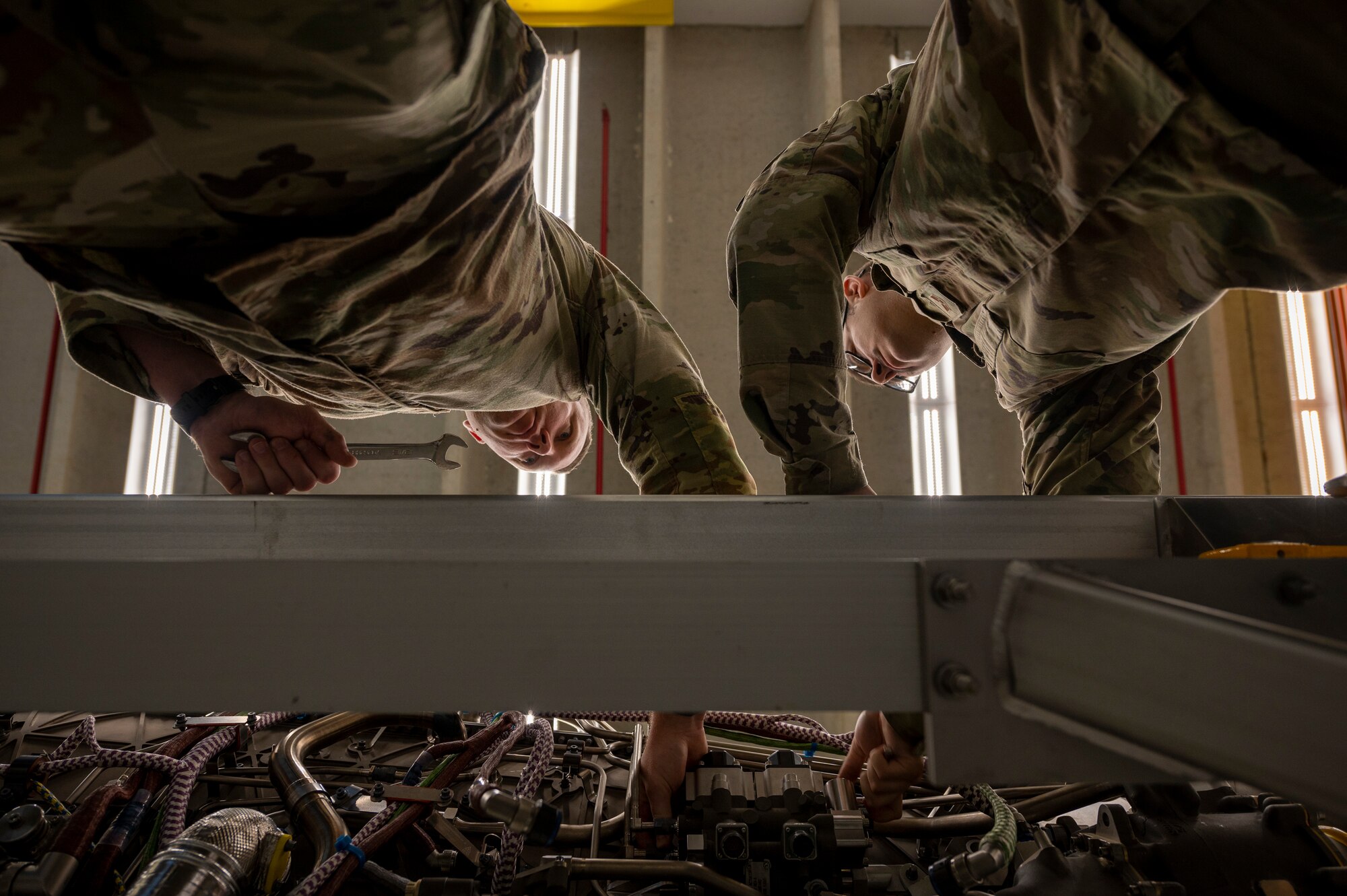 Airmen perform maintenance on an engine