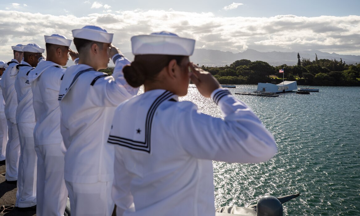 Sailors aboard USS Nimitz (CVN 68) render honors as the ship passes the USS Arizona Memorial while pulling in to Joint Base Pearl Harbor-Hickam.