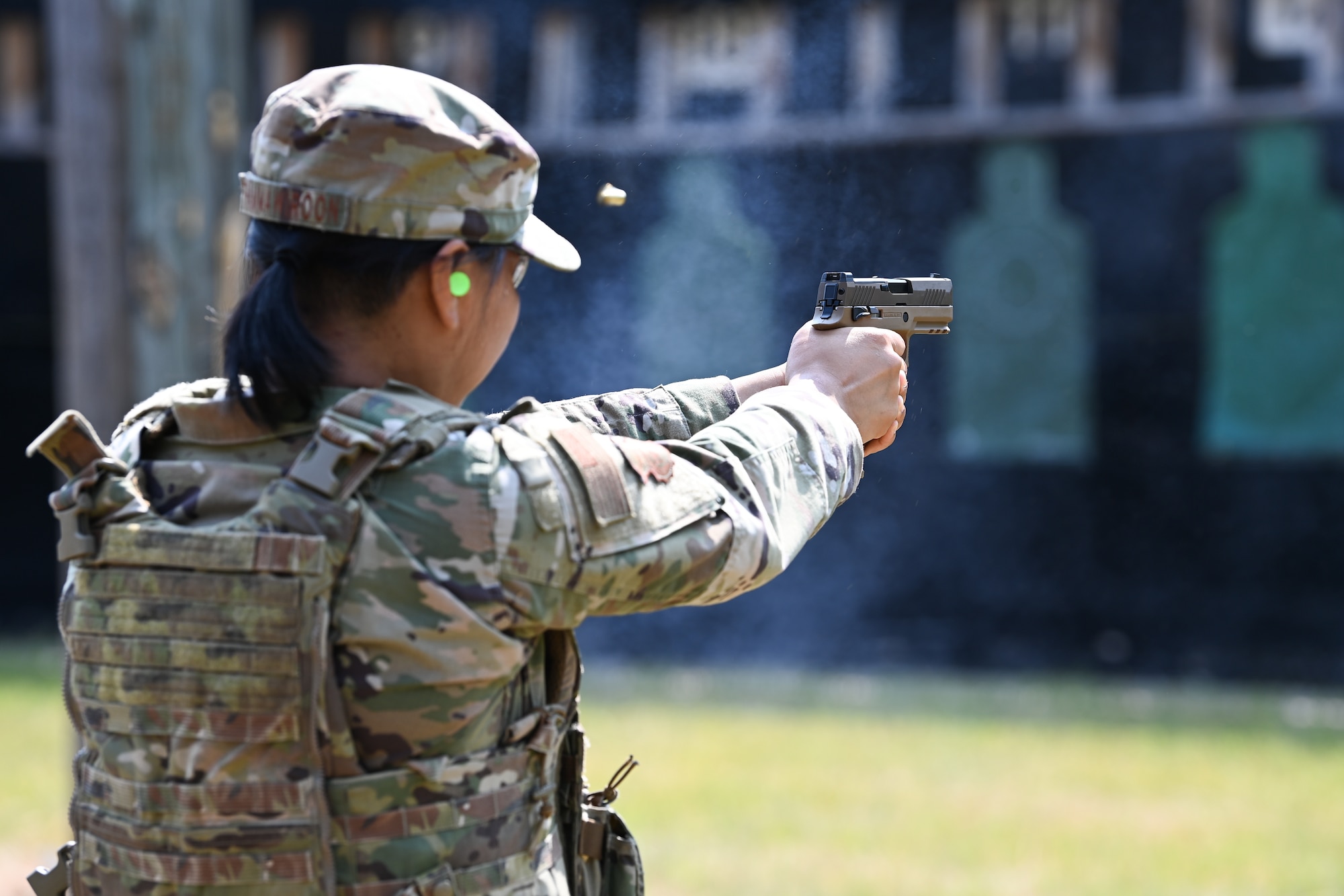 Female Airman shoots pistol at firing range