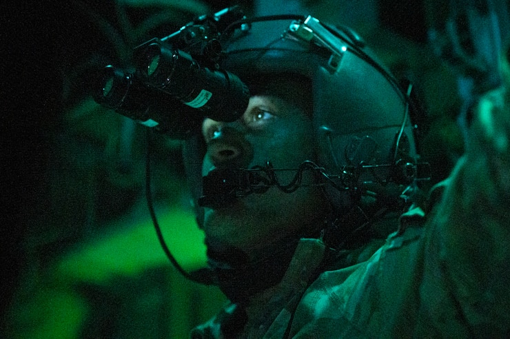 An Airman is photographed wearing headgear in lowlight conditions