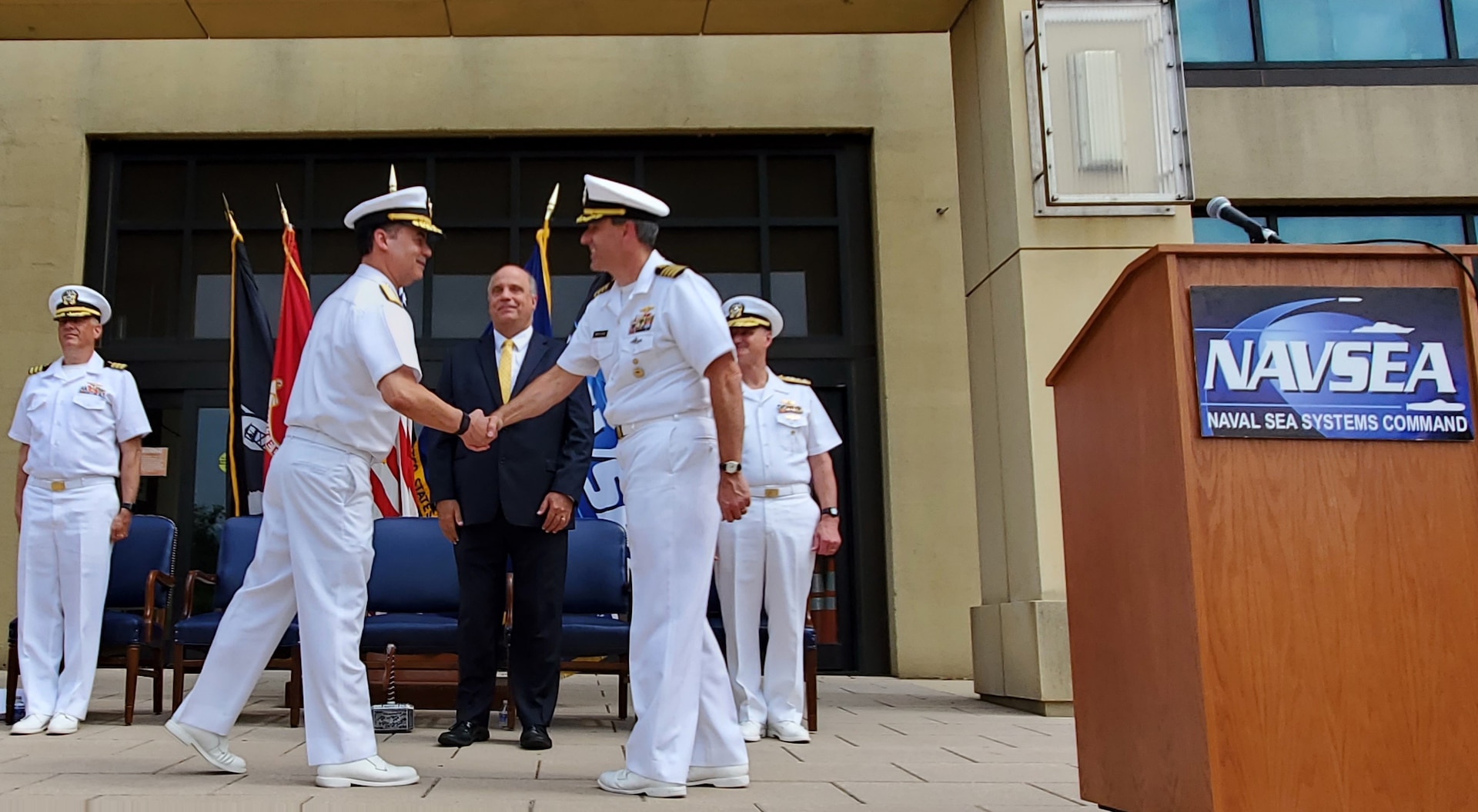 Rear Adm. Dave Goggins congratulates Capt. Lincoln Reifsteck upon relieving him as the Program Manager of the AUKUS Integration and Acquisition program office. Mr. Jay Stefany, Acting  Assistant Secretary of the Navy for Research, Development, and Acquisition oversaw the event at the Washington Navy Yard. (Courtesy Photo)