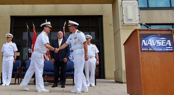 Rear Adm. Dave Goggins congratulates Capt. Lincoln Reifsteck upon relieving him as the Program Manager of the AUKUS Integration and Acquisition program office. Mr. Jay Stefany, Acting  Assistant Secretary of the Navy for Research, Development, and Acquisition oversaw the event at the Washington Navy Yard. (Courtesy Photo)