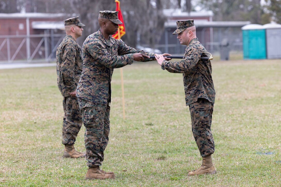 U.S. Marine Corps Lt. Col. Brian Carthon, commanding officer of II Marine Expeditionary Force Support Battalion, II MEF, left, delivers the sword to Sgt. Maj. Zane Moorman, oncoming sergeant major of II MSB, during the II MSB Sergeant Major Relief and Appointment ceremony aboard Marine Corps Base Camp Lejeune, North Carolina, March 2, 2023. The Relief and Appointment signifies the passing of authority from the outgoing sergeant major to the oncoming sergeant major. (U.S. Marine Corps photo by Lance Cpl. John Allen)