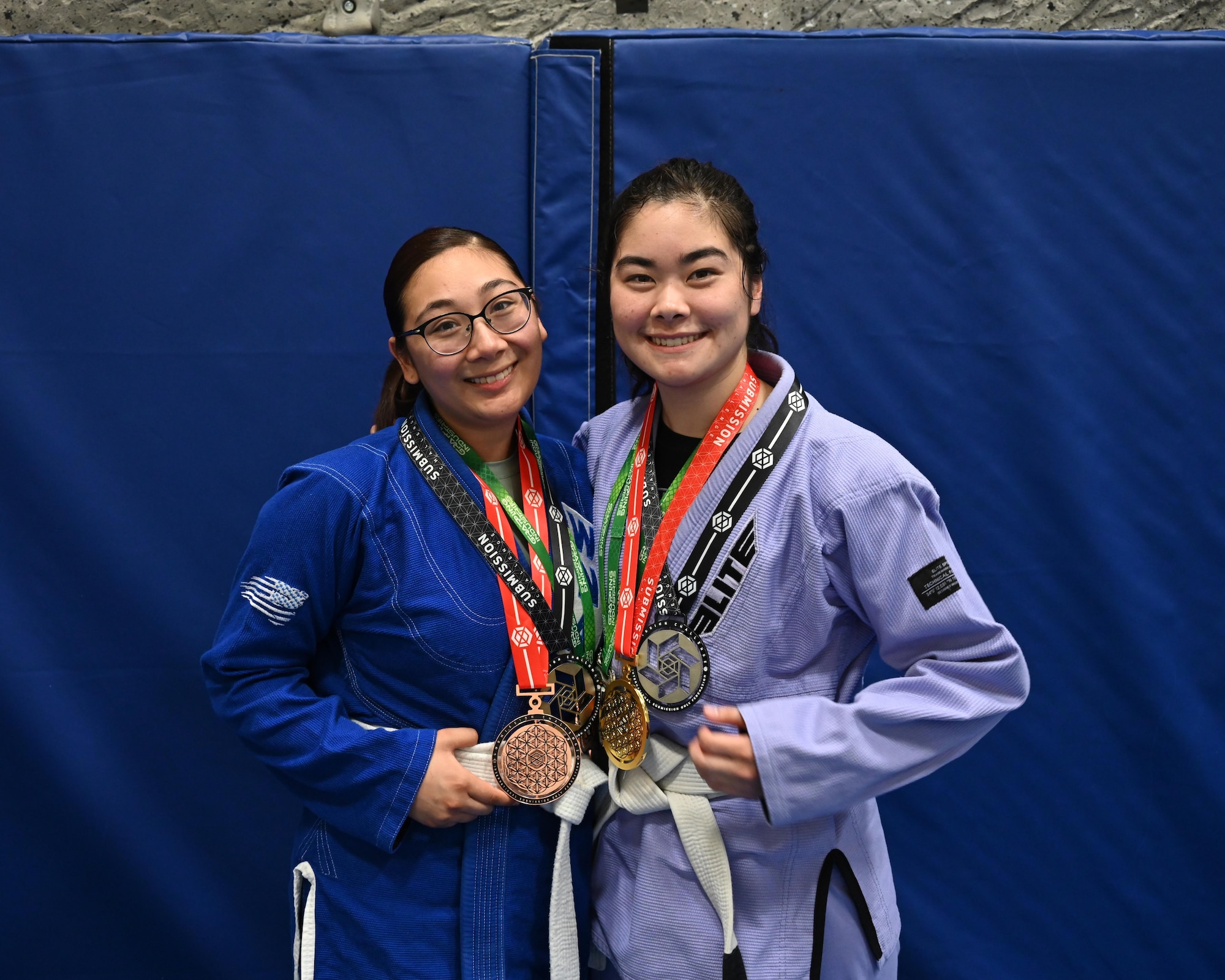Airman 1st Class Rachel Chi, 5th Communications Squadron communications security accountant, and Airman 1st Class Keoliani Tran, 5th Bomb Wing Chapel Corps religious affairs Airman, pose for a photo with medals they’ve won in Brazilian Jiu Jitsu tournaments at Minot Air Force Base, North Dakota, June 15, 2023. Through Task Force True North’s Warrior program, 115 Team Minot Airmen come together three times weekly to train in Brazilian Jiu Jitsu. (U.S. Air Force photo by Senior Airman Caleb S. Kimmell)