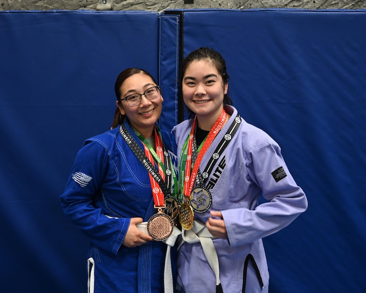 Airman 1st Class Rachel Chi, 5th Communications Squadron communications security accountant, and Airman 1st Class Keoliani Tran, 5th Bomb Wing Chapel Corps religious affairs Airman, pose for a photo with medals they’ve won in Brazilian Jiu Jitsu tournaments at Minot Air Force Base, North Dakota, June 15, 2023. Through Task Force True North’s Warrior program, 115 Team Minot Airmen come together three times weekly to train in Brazilian Jiu Jitsu. (U.S. Air Force photo by Senior Airman Caleb S. Kimmell)