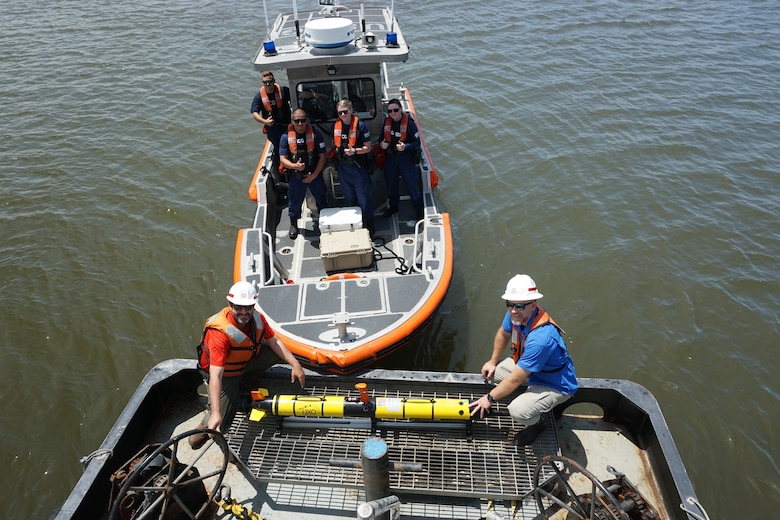 U.S. Army Engineer Research and Development Center Environmental Laboratory researchers Shea Hammond (front left) and Justin Wilkens (front right) on the back of a tugboat with the i3X0 EcoMapper, an autonomous underwater vehicle. A U.S. Coast Guard crew and support vessel provided support while the EcoMapper missions were underway. The EcoMapper was used to help respond to a Dredging Operations Technical Support (DOTS) request to monitor turbidity near a cutterhead dredge in the Bayou Rigaud Navigation Channel near Grand Isle, Louisiana.