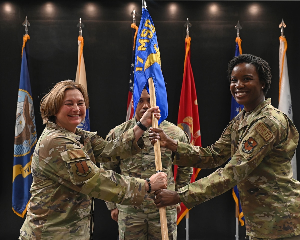 U.S. Air Force Col. Angelina Maguinness, 17th Training Wing commander, passes the guidon to Maj. Anita Sims, incoming 17th Contracting Squadron commander, during the change of command ceremony at the Powell Event Center, Goodfellow Air Force Base, Texas, June 21, 2023. Sims was formerly 32nd Student Squadron flight commander, leading multiple six-week Squadron Officer School courses. (U.S. Air Force photo by Airman 1st Class Zach Heimbuch)