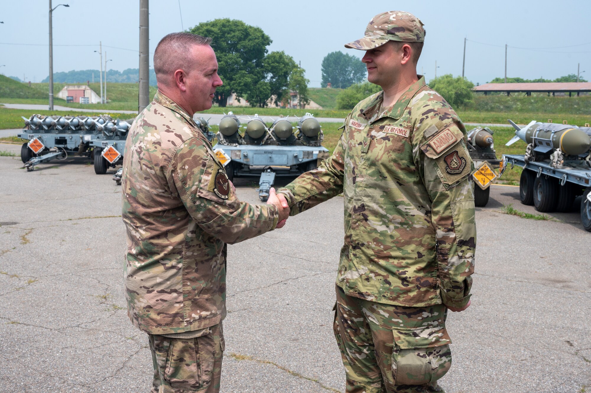 U.S. Air Force Chief Master Sgt. David Wolfe, left, Pacific Air Forces (PACAF) command chief, coins Senior Airman Ethan Harsh, 51st Munitions Squadron stockpile management crew chief (SMCC), at Osan Air Base, Republic of Korea, June 14, 2023. Harsh was coined for his exemplary performance as a SMCC. Harsh is responsible for the safe transportation, storage and handling of diverse munitions stockpiles as well as maintaining munitions storage structures, ensuring the safety, security and reliability of Osan’s materiel stockpiles. (U.S. Air Force photo by Senior Airman Aaron Edwards)