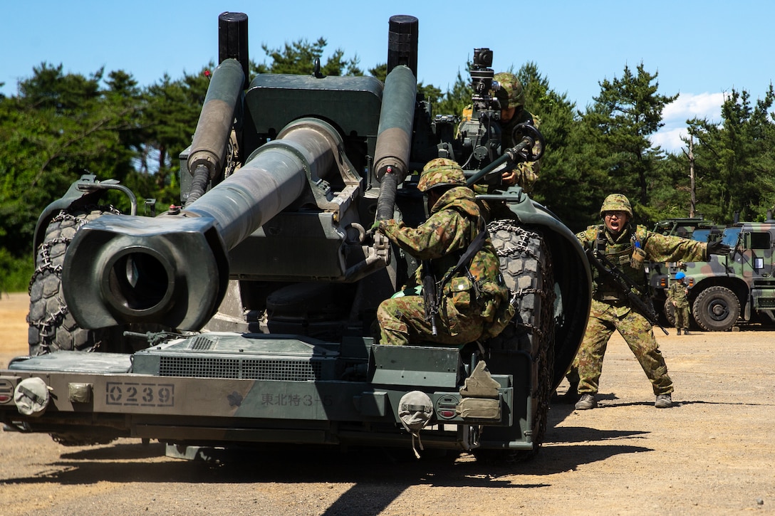 Japan Ground Self Defense Force soldiers with North Eastern Army Artillery Unit display an artillery cannon after the completion of Artillery Relocation Training Program 23.1 at Ojojihara Maneuver Area, Miyagi, Japan, June 5, 2023. ARTP provides Marines the opportunity to rehearse live-fire operations across a range of climates and conditions, providing combat ready forces in the Indo-Pacific. The Marines are currently deployed with 3d Battalion, 12th Marines, 3d Marine Division. (U.S. Marine Corps photo by Cpl. Michael Taggart)