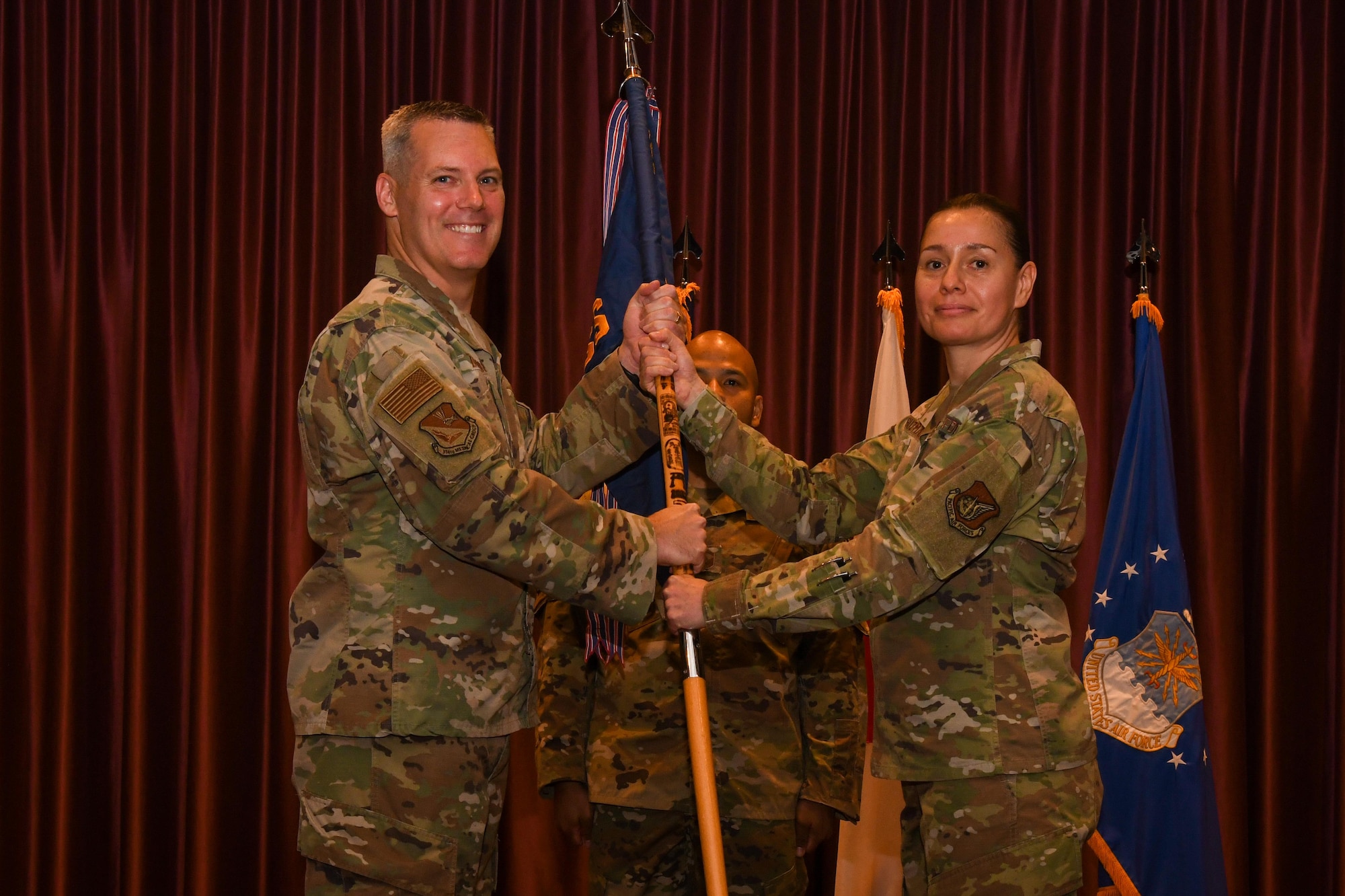 Two service members hold a guidon.