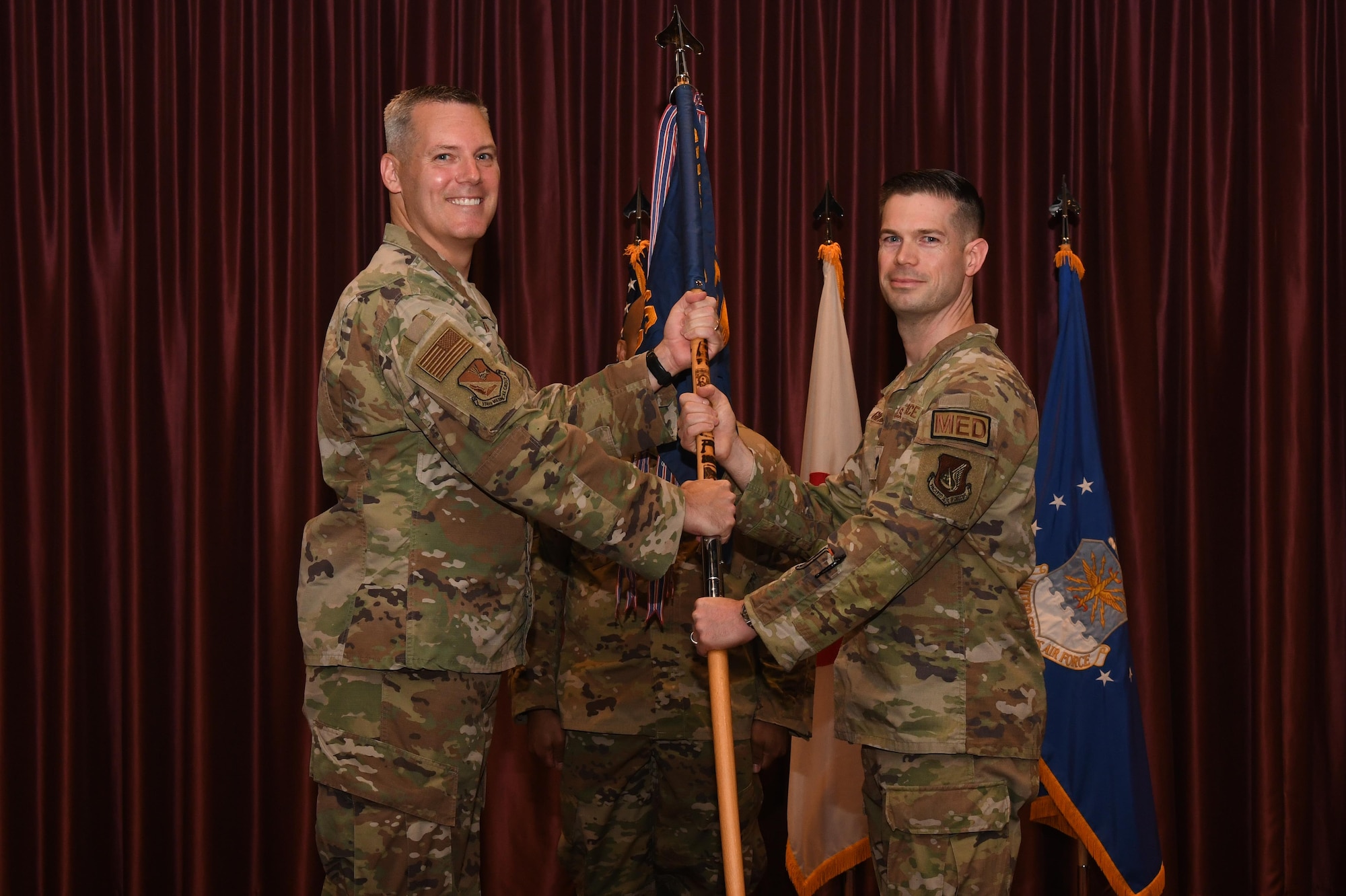 Two service members hold a guidon.