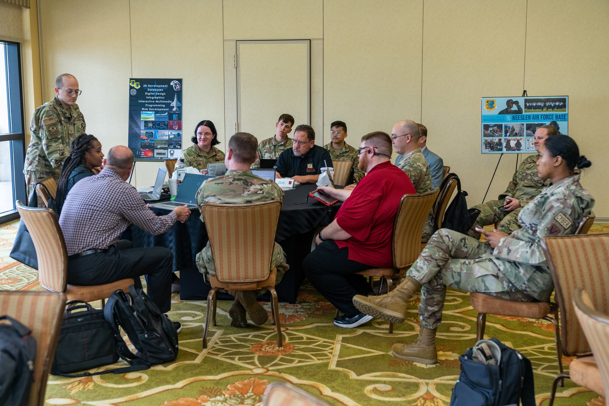 U.S. Air Force and civilian personnel break away at different tables to discuss the major themes presented during the Cyber Training Summit at Keesler Air Force Base, Mississippi, June 5, 2023.