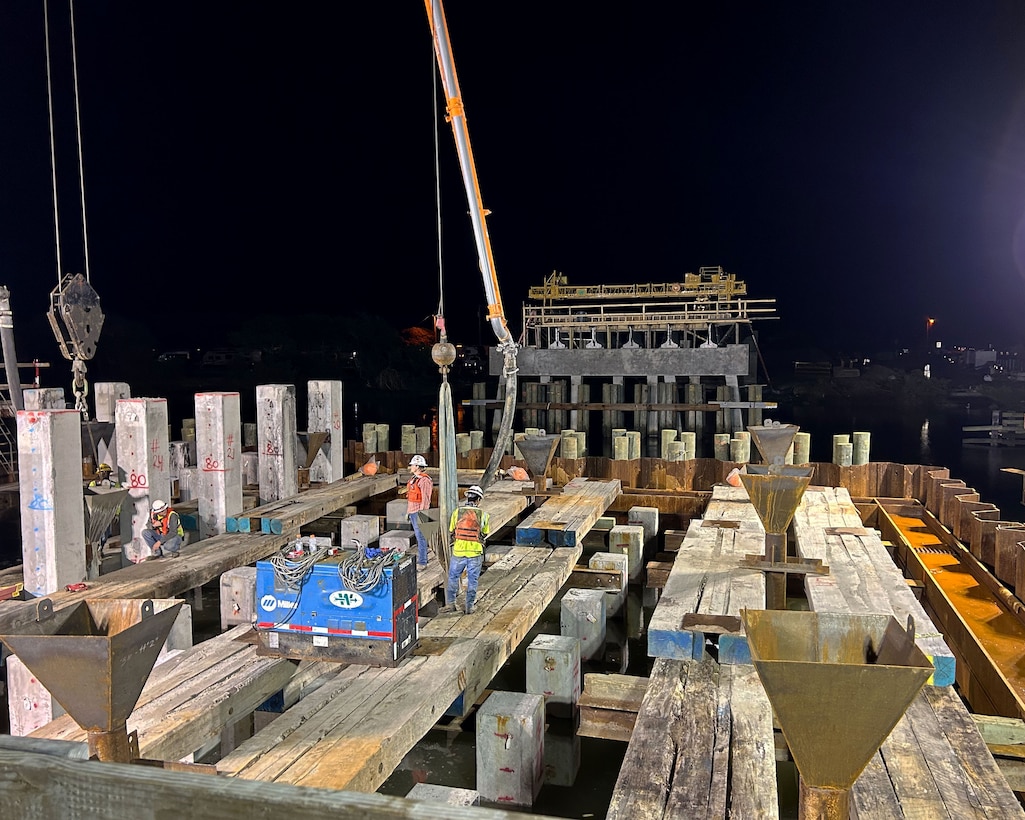 Contractors work through the night to place 2,498 cubic yards of concrete for a tremie seal at Onslow Beach Bridge,  Marine Corps Base Camp Lejeune. Crews working at the  site have been working 23 ft below the water line while staying nice and dry with the help of a millennia old technology: the cofferdam.