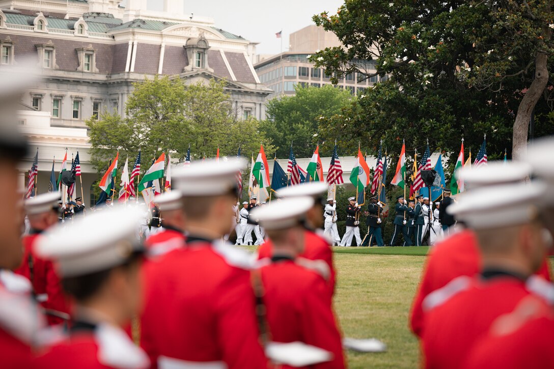 The Marine Band stands at attention on the South Lawn of the White House as flags of India, the United States and all U.S. states and territories are paraded up the driveway, during a rehearsal on June 20, 2023 for the State Arrival of Indian Prime Minister Modi.