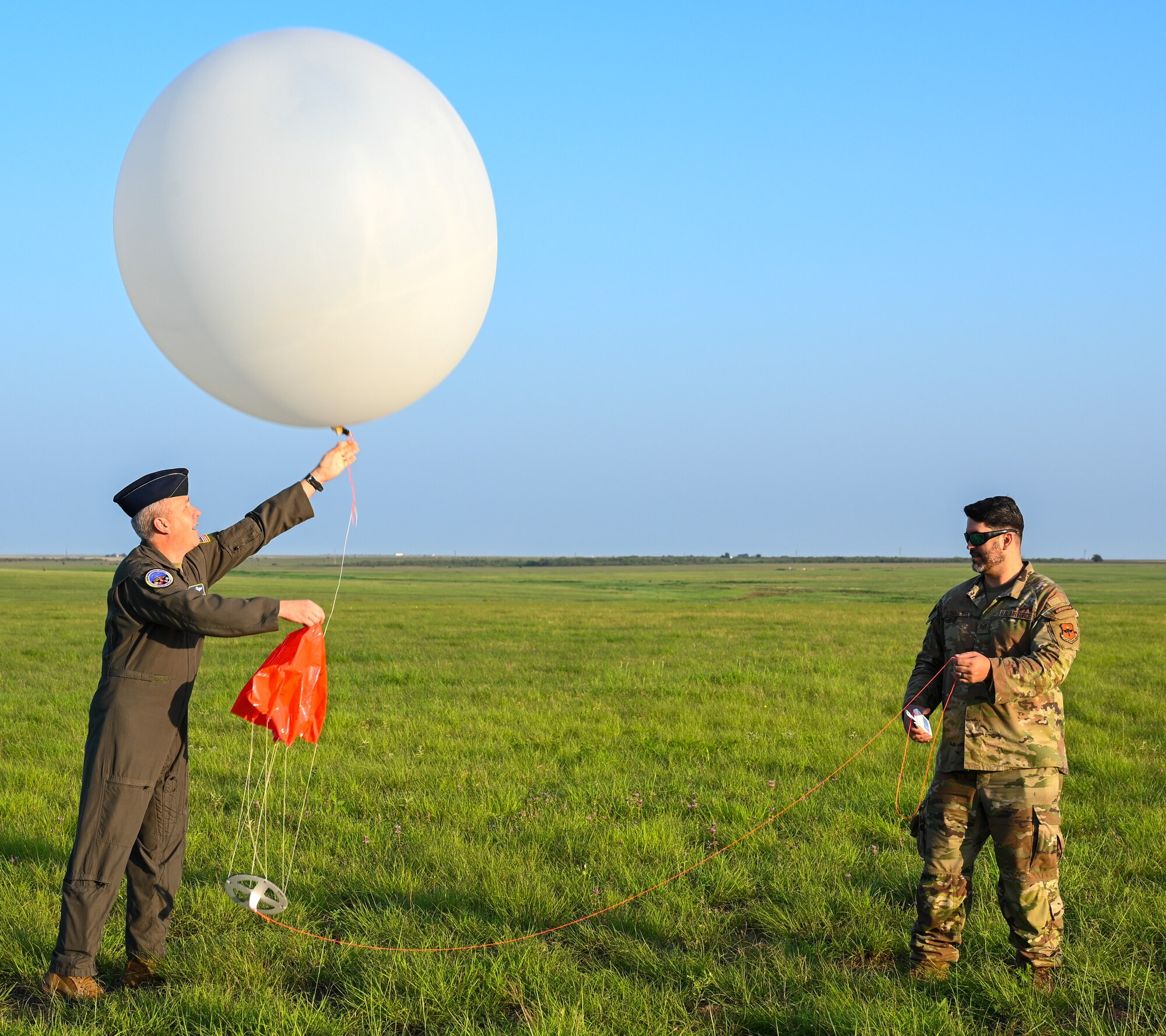 U.S. Air Force Col. Scott Linck, 97th Operations Group commander, and Tech. Sgt. Jared Lindley, 97th Operations Support Squadron noncommissioned officer in charge of weather operations, prepare to launch a weather balloon at the Sooner Drop Zone, June 15,2023. The data from the balloons launched throughout the new program will help the weather flight analyze the upper levels of the atmosphere to give them a better forecast for severe weather in the near future. (U.S. Air Force photo by Airman 1st Class Heidi Bucins)