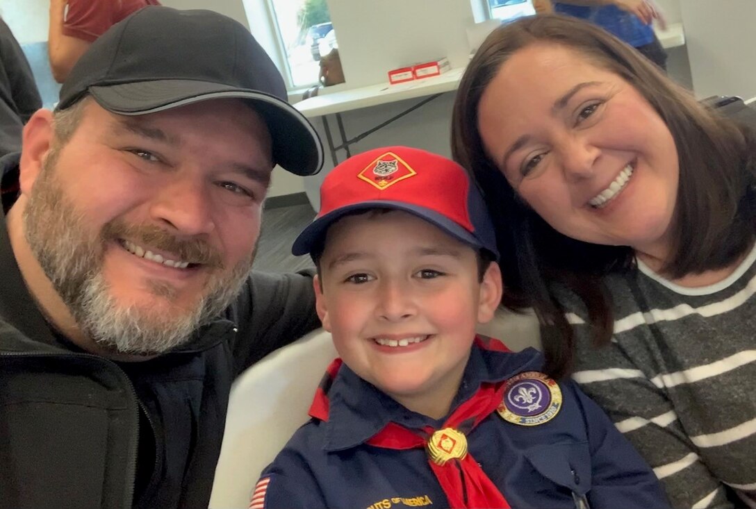 Man, cub scout, and woman take a selfie