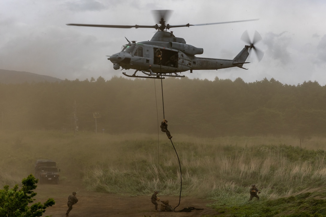 U.S. Marines with 3rd Reconnaissance Battalion fast rope from a UH-1Y Venom helicopter with Marine Light Attack Helicopter Squadron (HMLA) 169 during Fuji Viper at Camp Fuji, Japan, June 21, 2023. Fuji Viper provides 1st Marine Aircraft Wing with realistic training opportunities to exercise combined arms and maintain proficiency, lethality, and readiness.