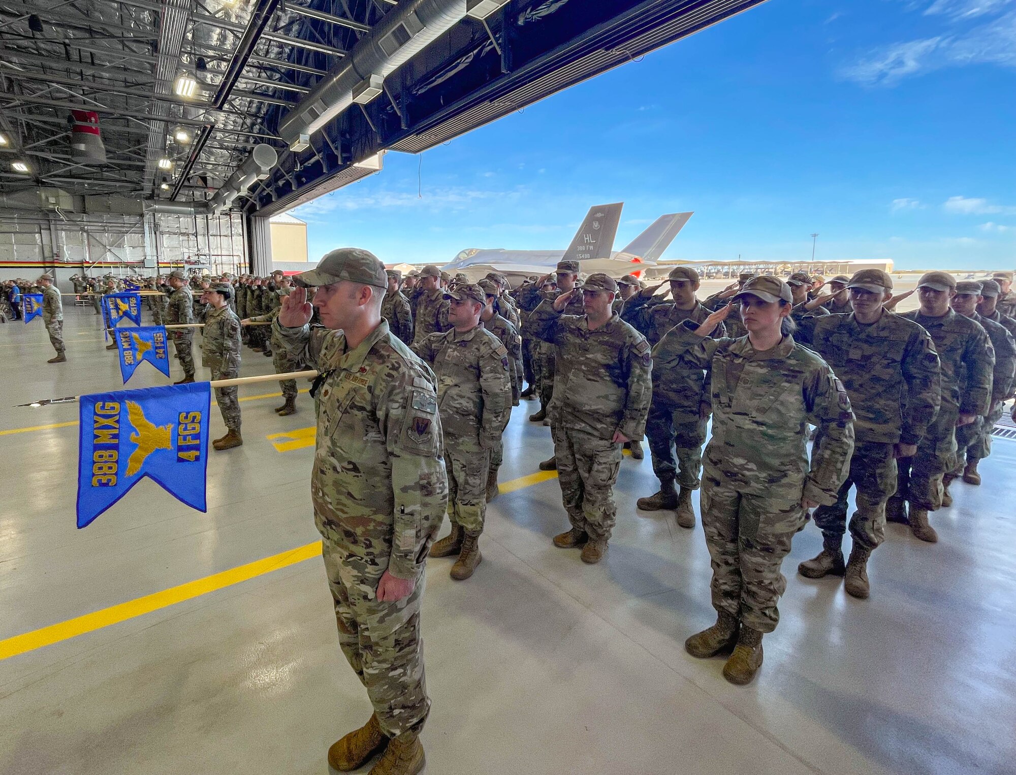 A photo of Airmen saluting in formation.