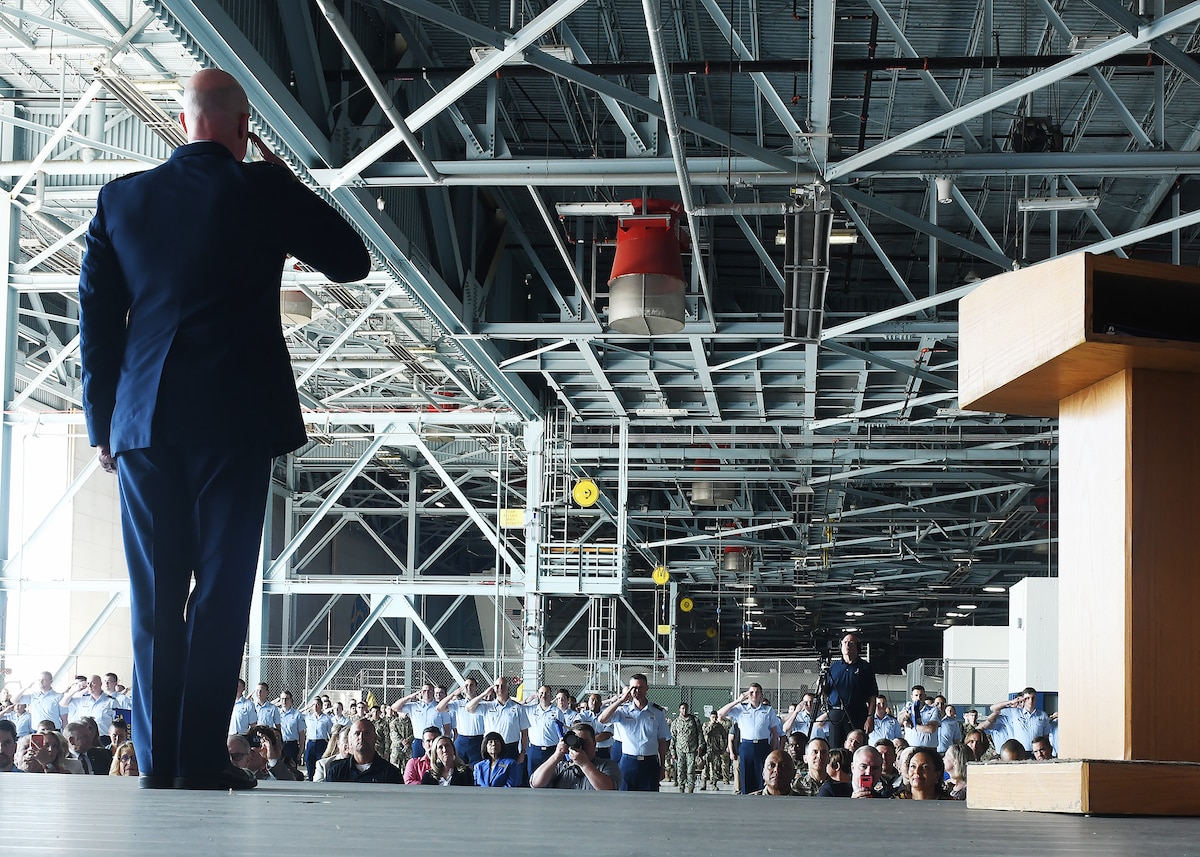 Man salutes formation in an aircraft maintenance dock
