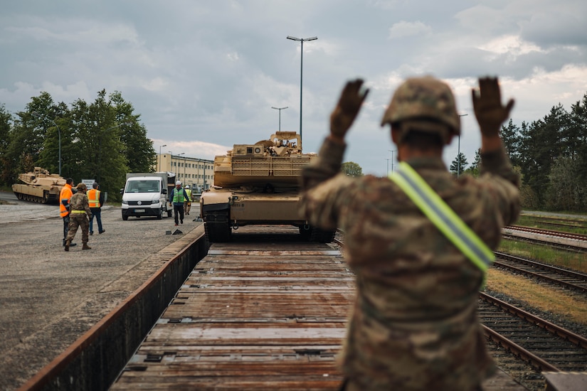 A soldier directs a tank for offload.