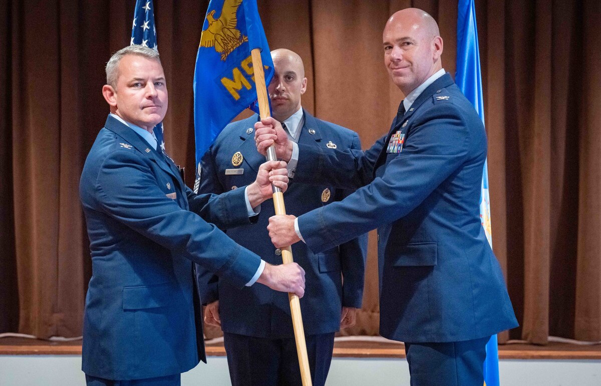 Meeker and Brazel hold guidon. 88 MSG Chief in the center behind the guidon.
