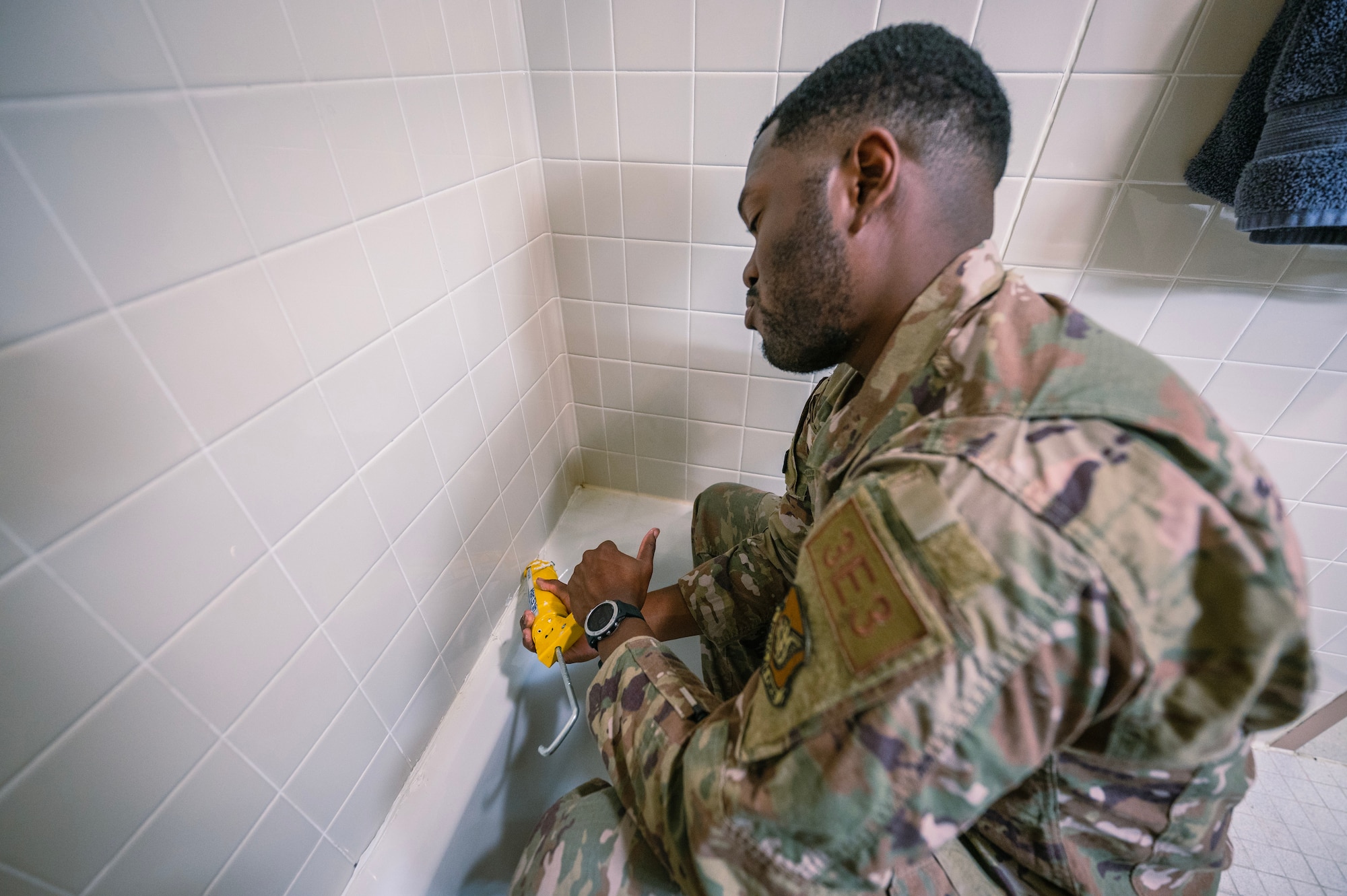 Staff Sgt. Brian Smith applies caulk to a bathtub during his shift at Kunsan Air Base